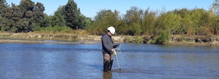 Profesional midiendo en el cauce de un río